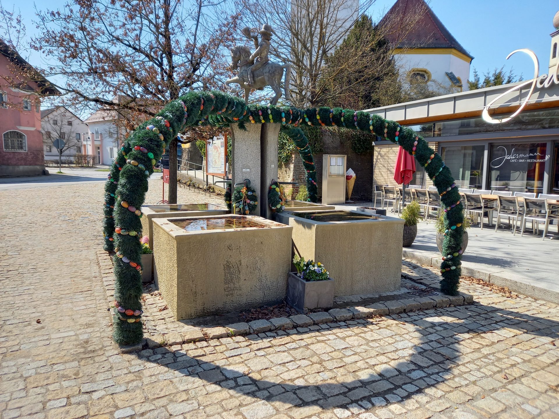 Der Osterbrunnen wird von den ersten Frühlingssonnenstrahlen angestrahlt